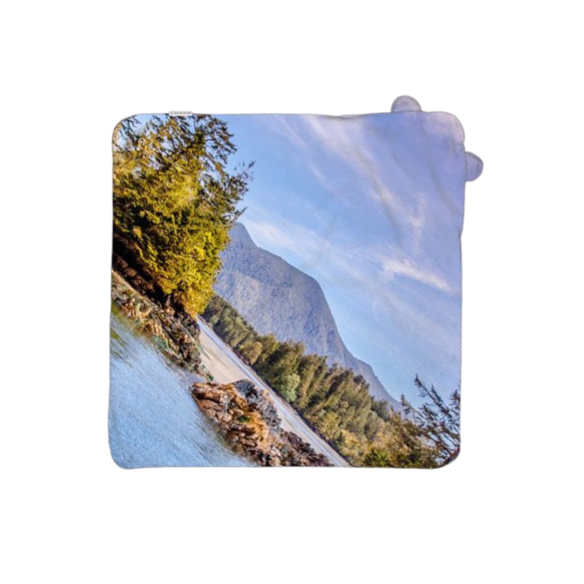 Rectangular towel with a scenic design of a mountain and trees.