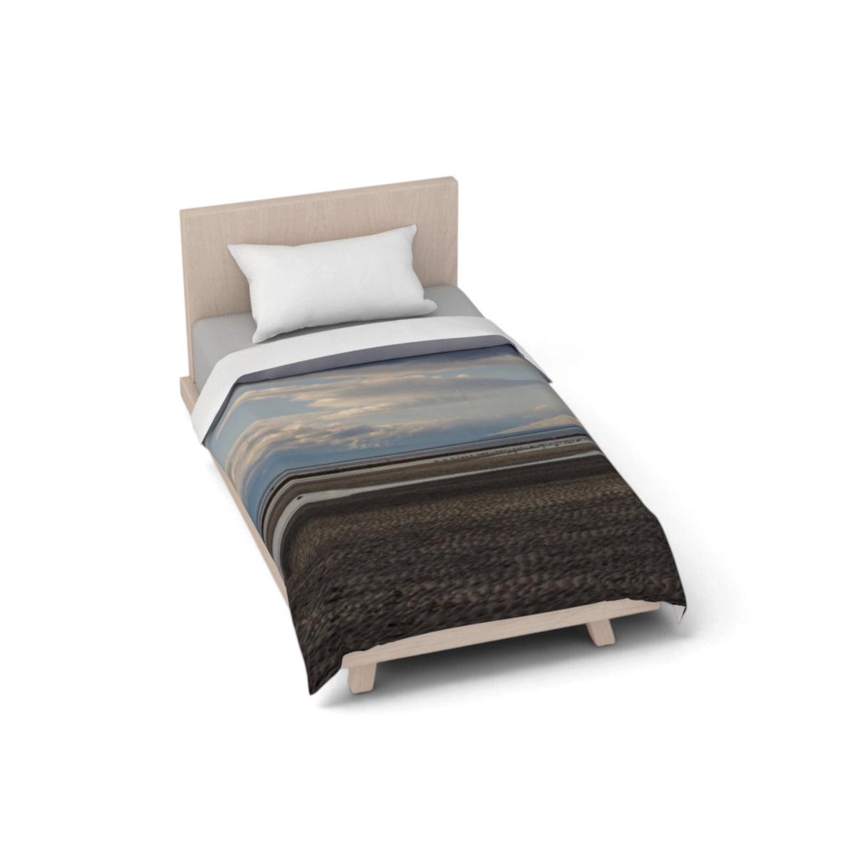 A single bed with a light wood frame and upholstered headboard, styled with a white pillow and a duvet cover featuring a landscape print with blue sky, clouds, and dark textured foreground. The bed is shown on a clean white background with a soft shadow.