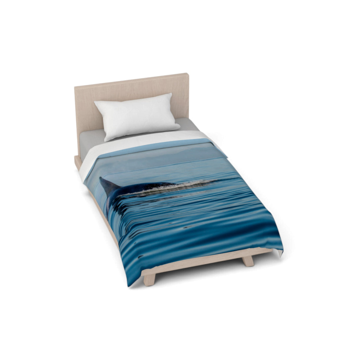 A single bed with a light wood frame and a white pillow, shown on a clean white background. The bed is covered with a blue ocean-themed duvet featuring a shark fin and rippling water print.