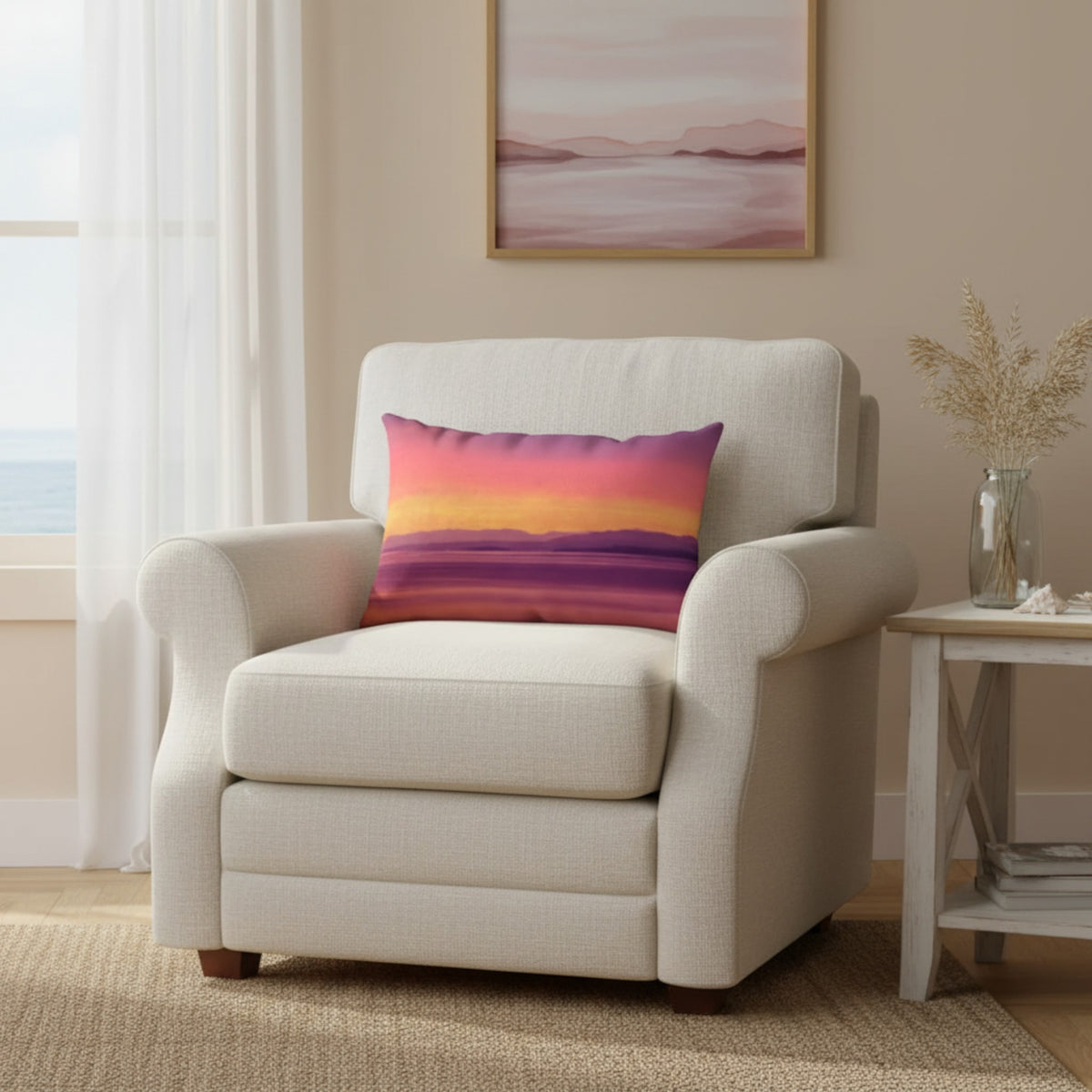 A cream-colored upholstered armchair in a bright living room setting, featuring a square throw pillow with a colorful sunset gradient pattern in pink, orange, yellow, and purple.