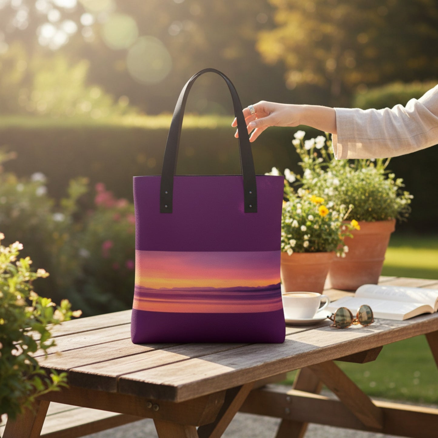 Purple tote bag with sunset design on a wooden table outdoors