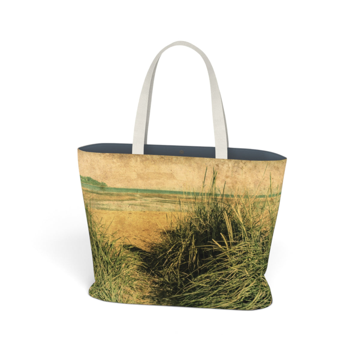 A tote bag featuring a vintage-style landscape print of beach grasses, with a dark navy blue interior and light gray fabric handles, shown against a plain white background.