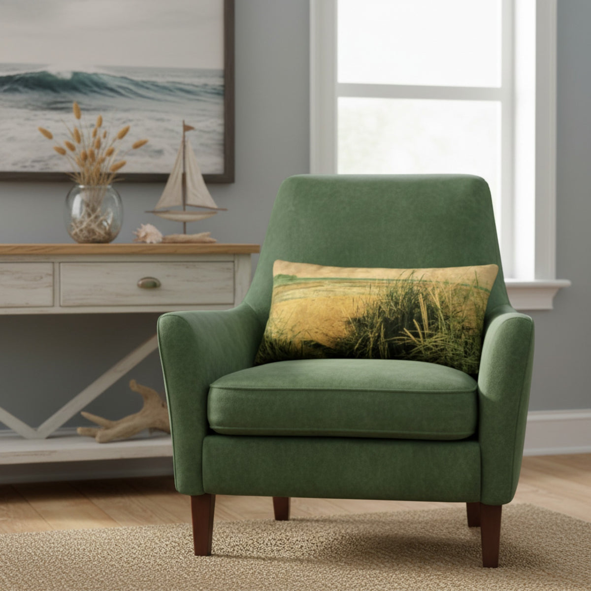 A green upholstered accent chair with dark wood legs, styled in a coastal-themed room with a matching green pillow featuring a beach grass print, set in front of a console table and window.