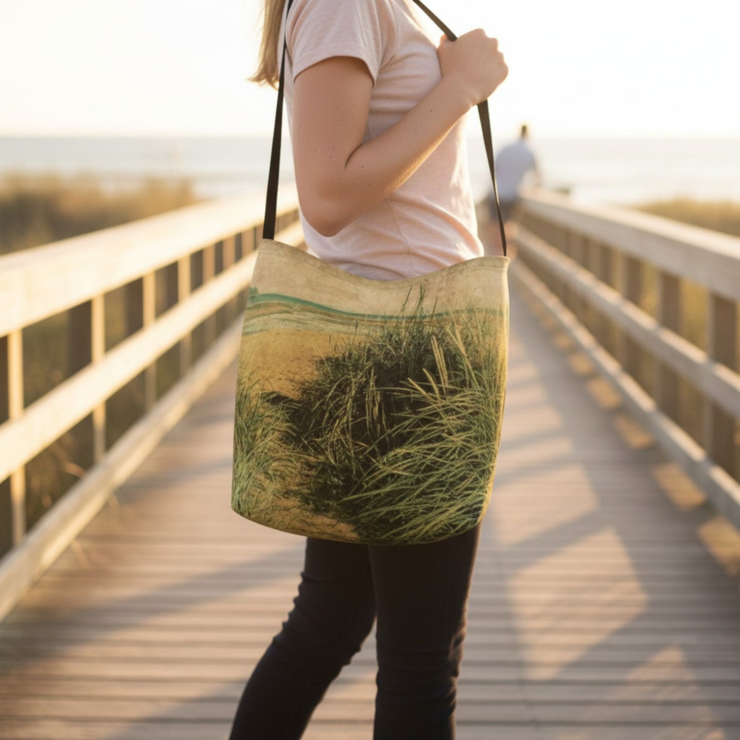 Person holding a beach patterned bag on a wooden bridge