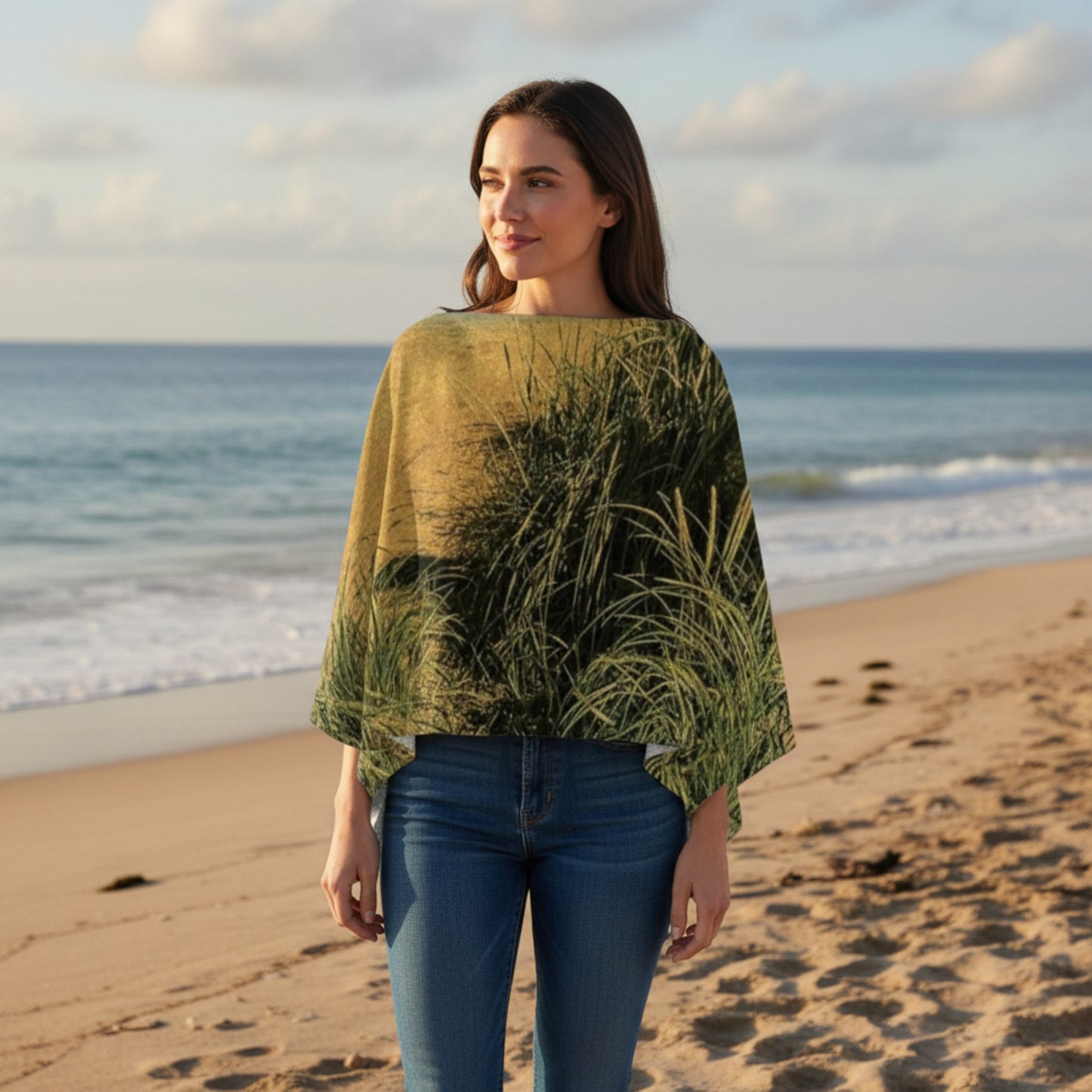 woman wearing a poncho walking on the beach