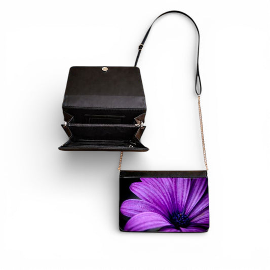 Black handbag with a purple flower design on a white background