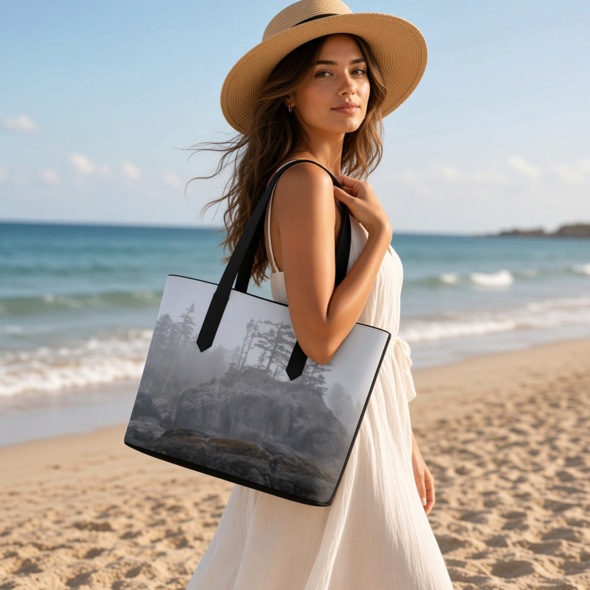 woman in a white dress walking on the beach carrying a ocean foggy landscape tote bag