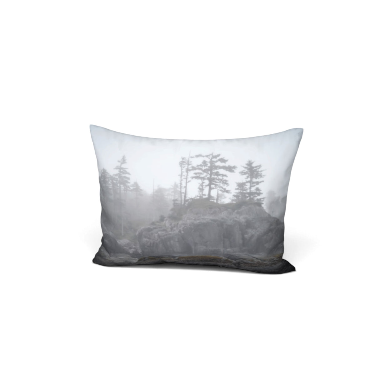 A rectangular throw pillow featuring a misty mountain pine forest landscape print in shades of gray, white, and black, shown against a plain white background.