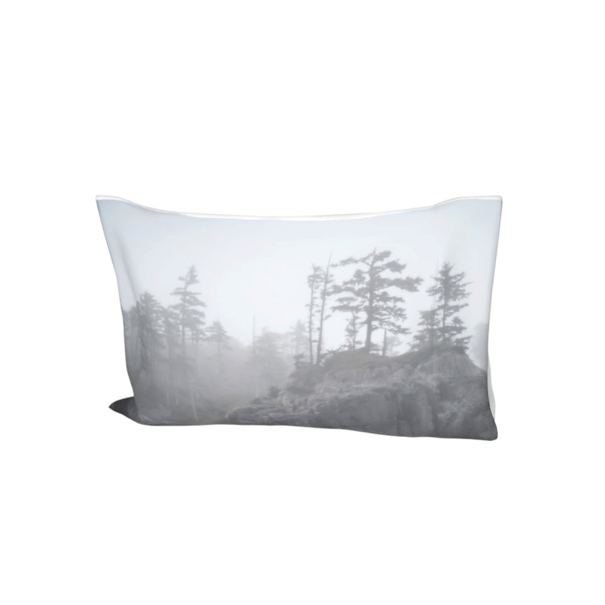 A rectangular throw pillow featuring a printed grayscale landscape design of pine trees in a foggy forest, shown against a plain white background.