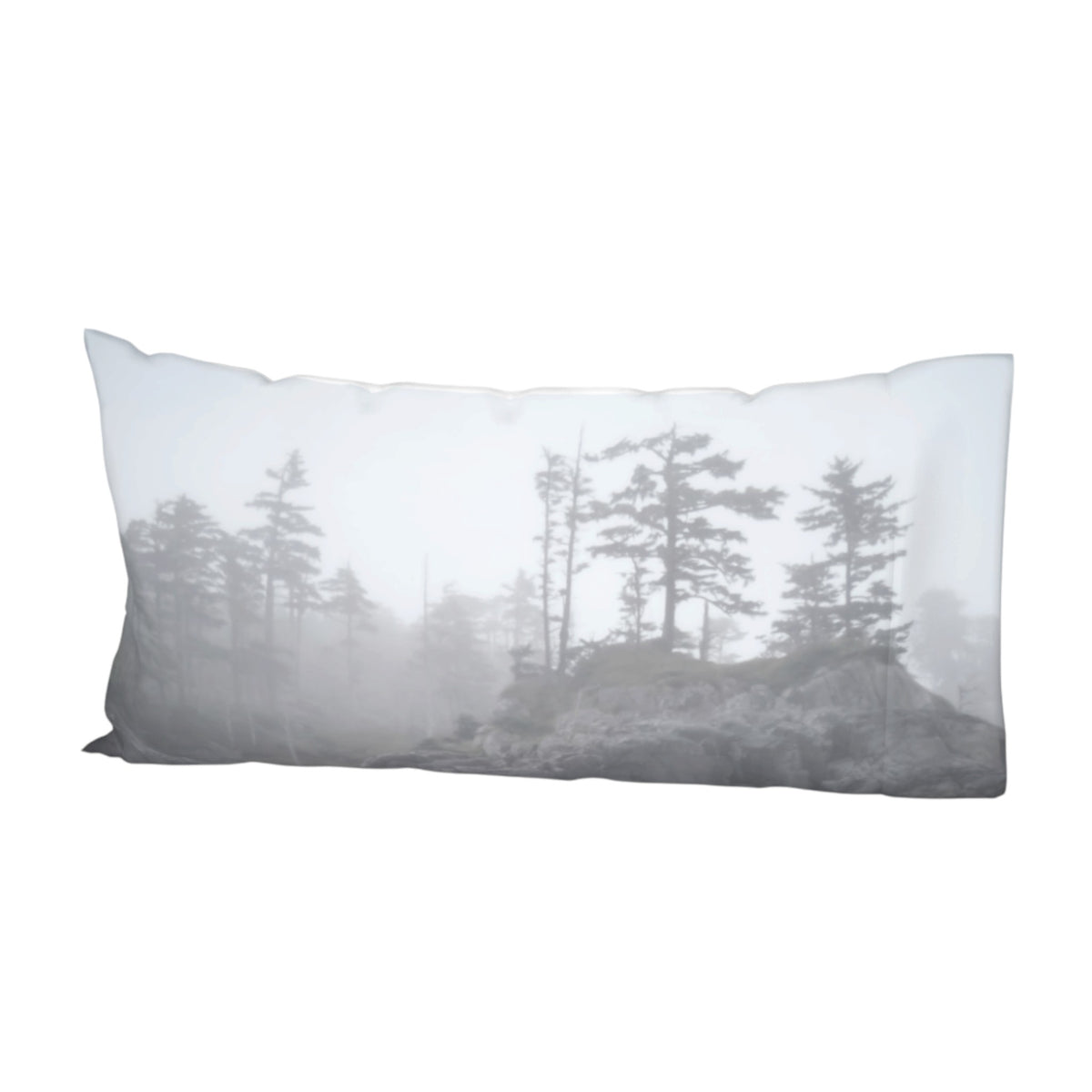 A rectangular lumbar pillow featuring a monochrome misty forest print with pine trees and rocks in shades of gray, white, and black, shown against a plain white background.