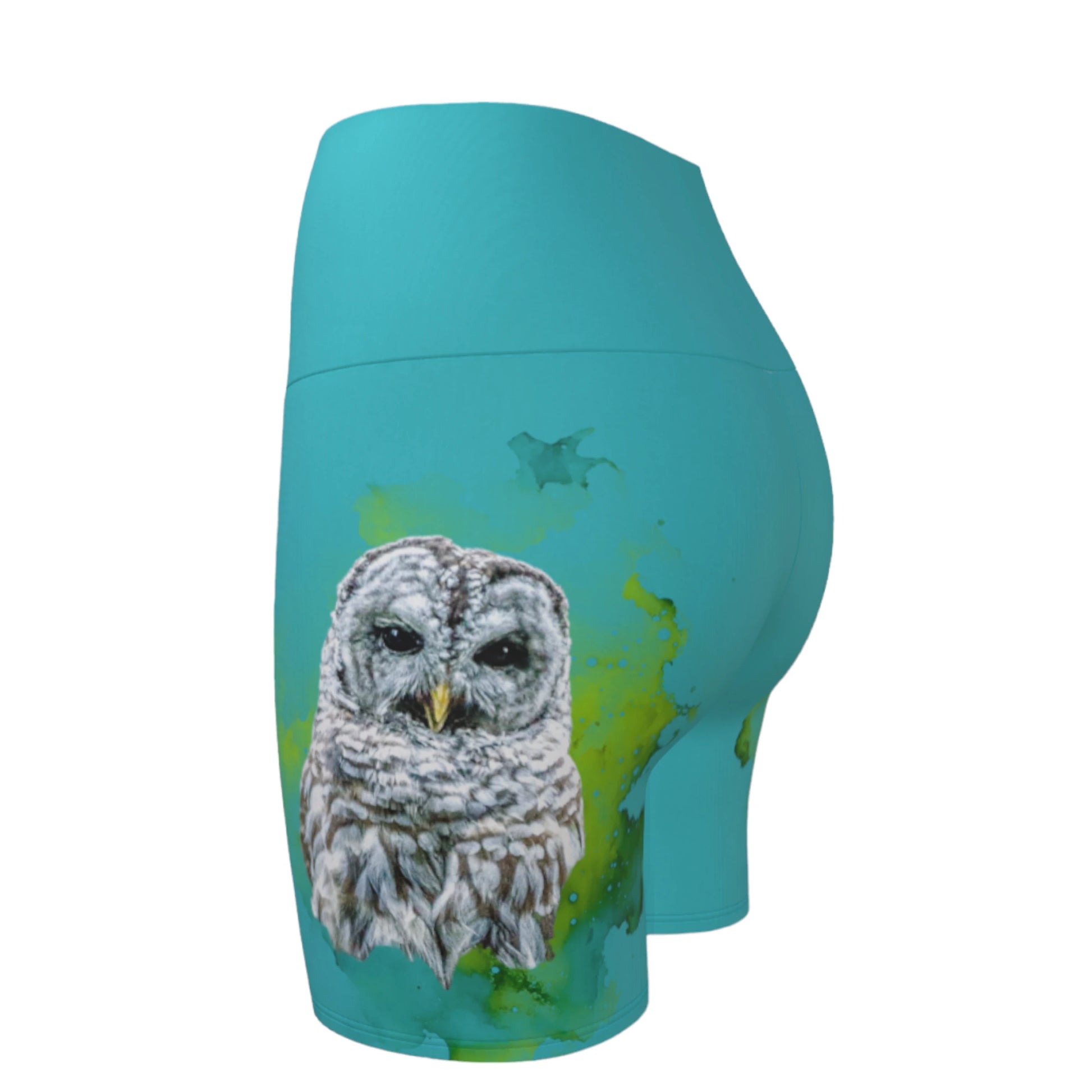 Wise owl yoga shorts features a barred owl printed on the shorts.  The rest of the shorts is turquoise in colour.