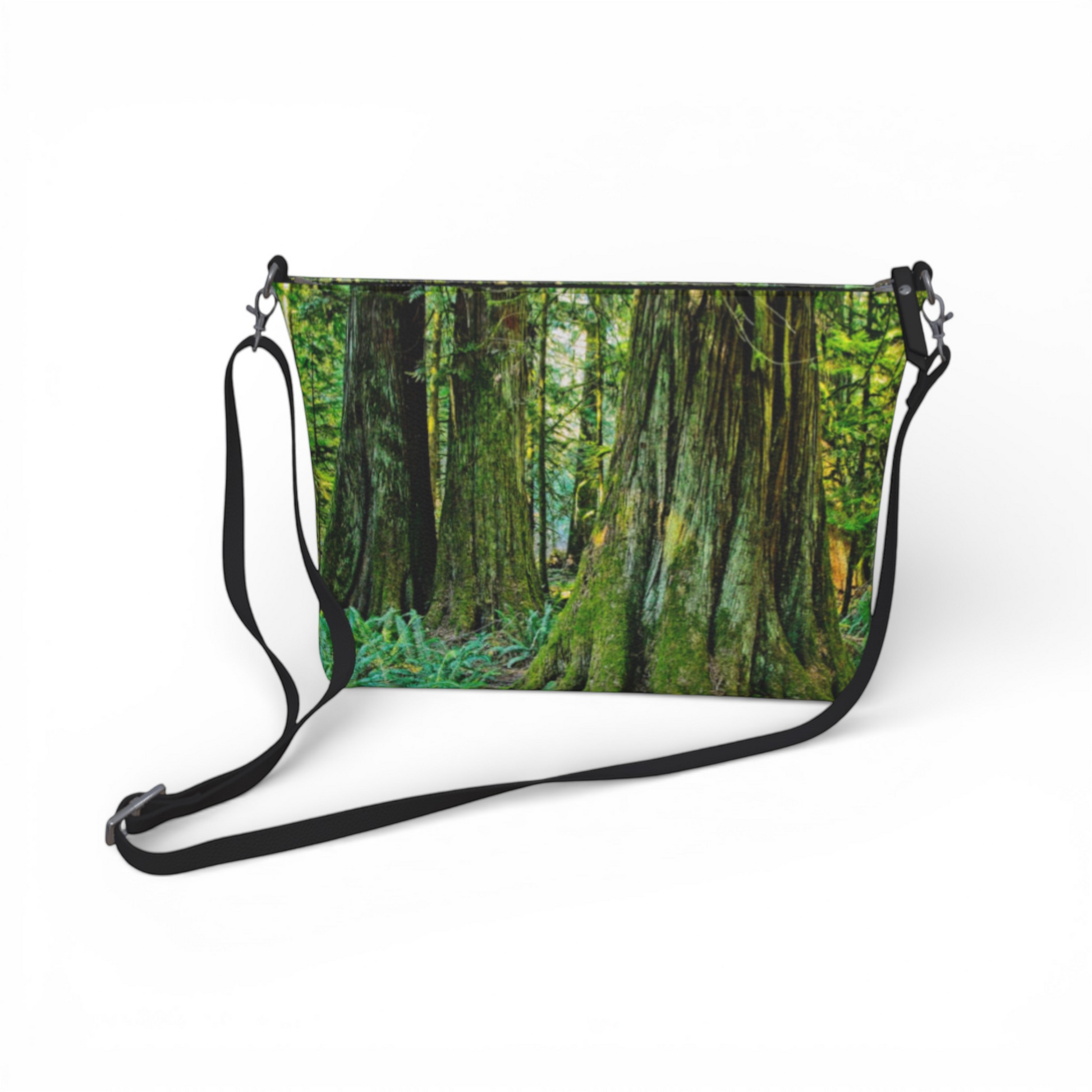 Van Isle Goddess crossbody purse with a forest print, adjustable strap, and metal hardware. Made from vegan leather.