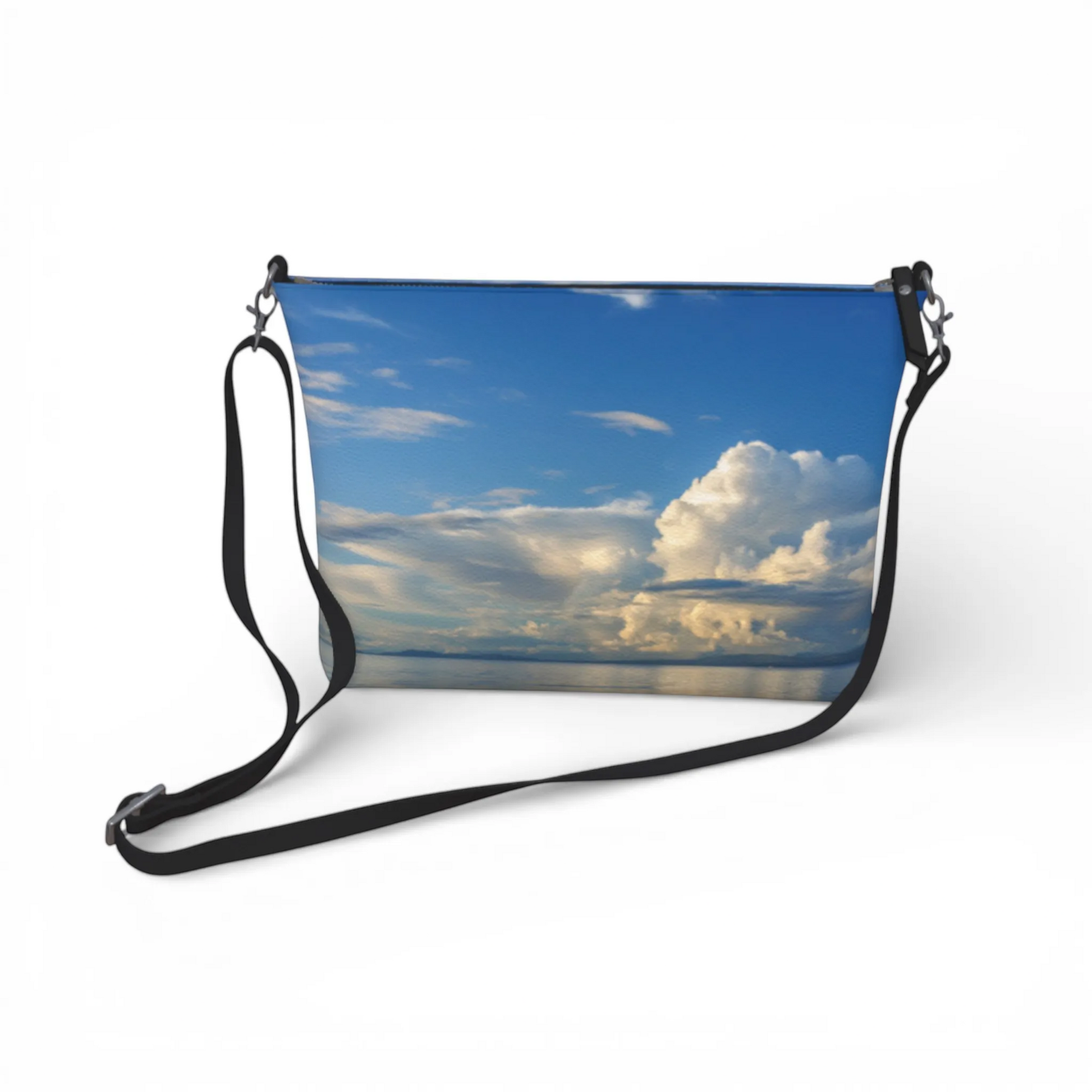 Van Isle Goddess Qualicum Beach crossbody purse with a sky and clouds print, adjustable strap, and metal hardware.