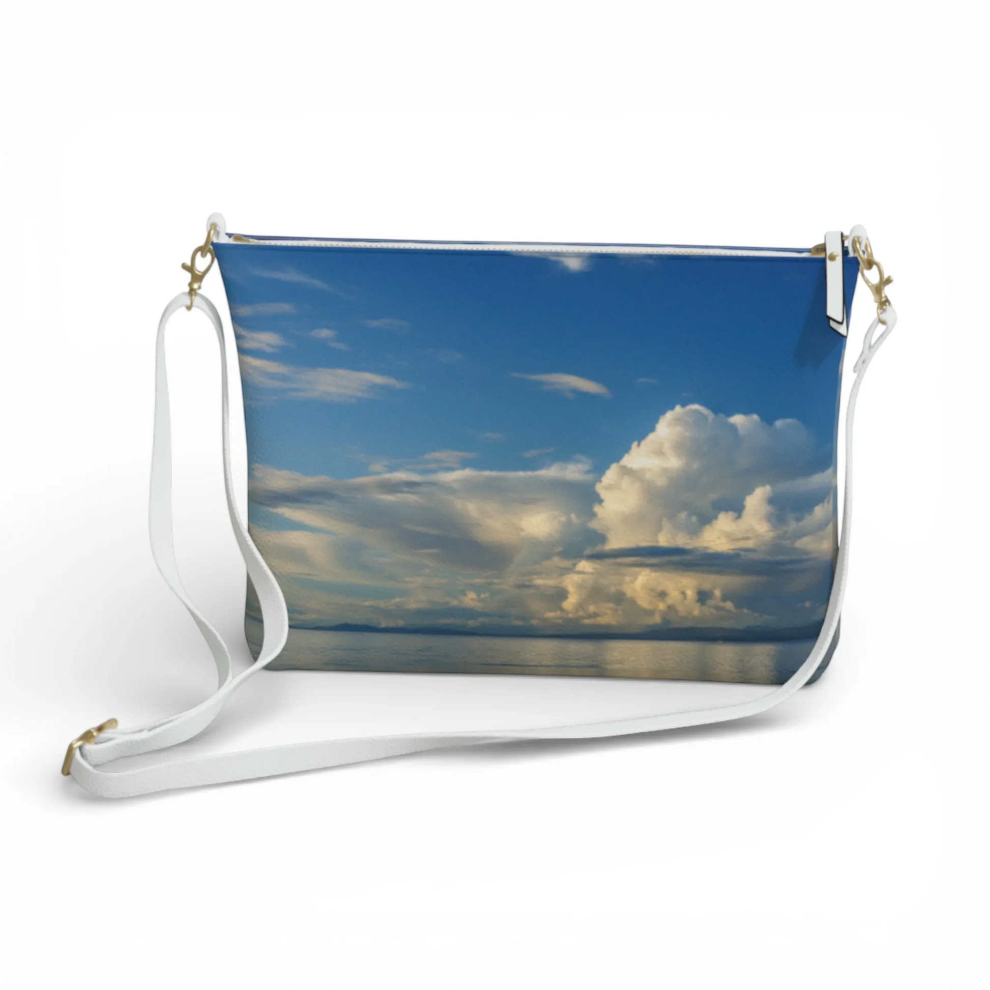 Van Isle Goddess Qualicum Beach crossbody purse with a sky and ocean print, adjustable white strap, and gold hardware.