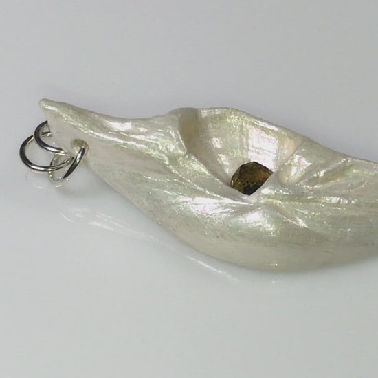 A video showcasing Seer is a natural seashell pendant with a beautiful 5mm rose cut Smokey Quartz compliments the pendant.