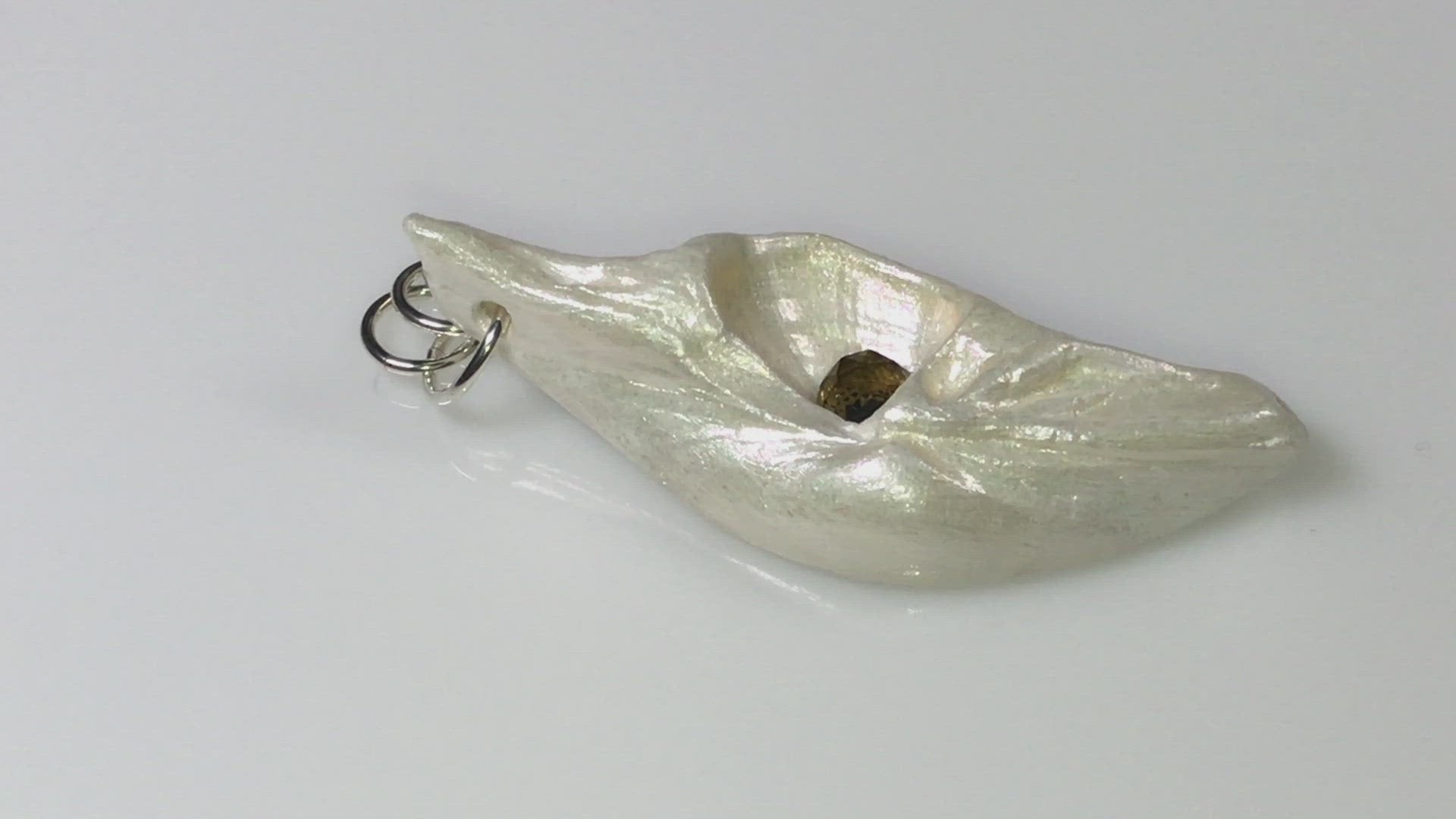 A video showcasing Seer is a natural seashell pendant with a beautiful 5mm rose cut Smokey Quartz compliments the pendant.