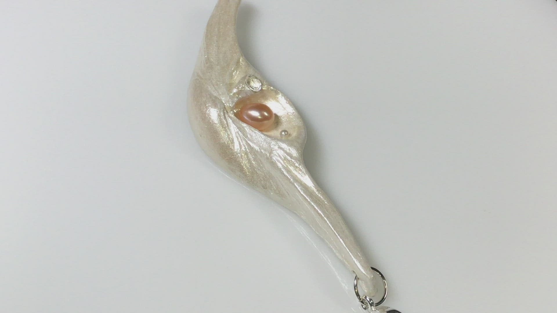 A video showcasing Nefertiti natural seashell and a real 8 mm pink freshwater Pearl, a baby pearl and a 5mm faceted Herkimer diamond compliments the pendant.