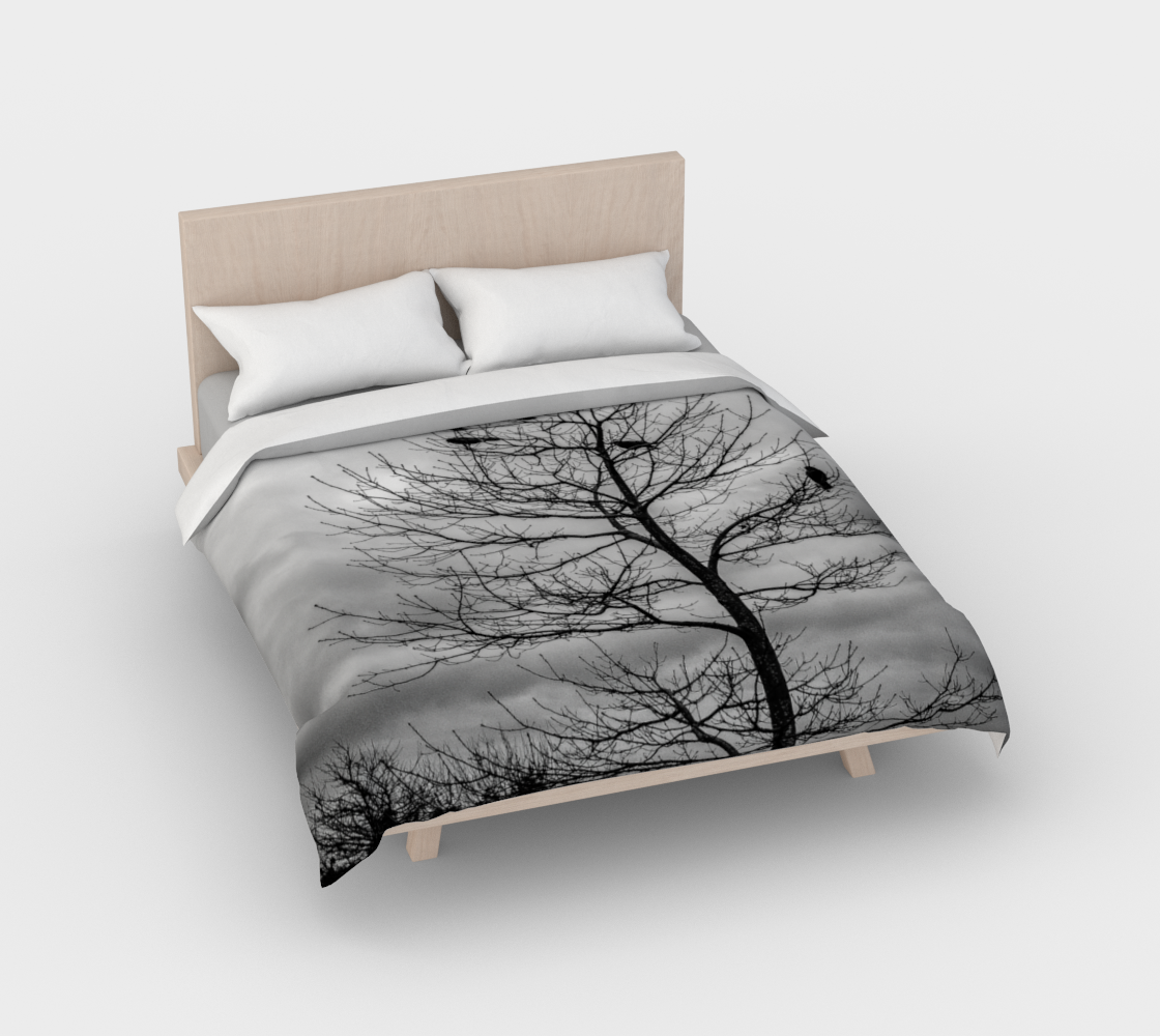 Cotton duvet cover on a queen sized bed. The image on the duvet cover is that of Blackbirds such as a crow perched in a tree.