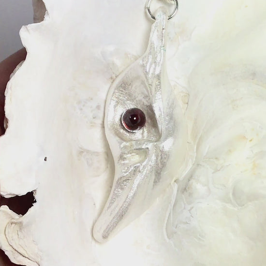 A video Pomegranate natural seashell pendant is adorned with a stunning Garnet gemstone.