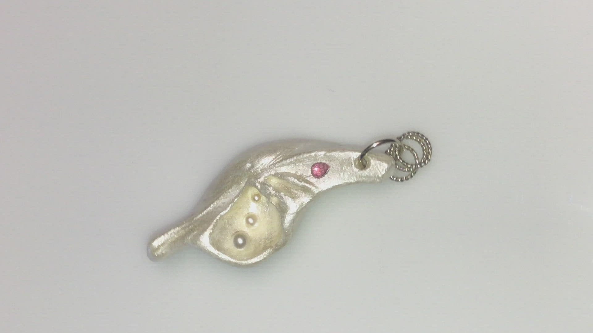 A video A trio of white baby freshwater pearls and a teardrop rose cut pink tourmaline gemstone compliments the seashell pendant beautifully.