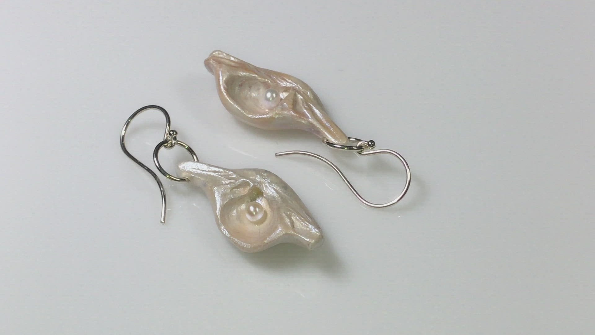 A video showcasing Victoria natural seashell earrings with real baby freshwater pearls. 