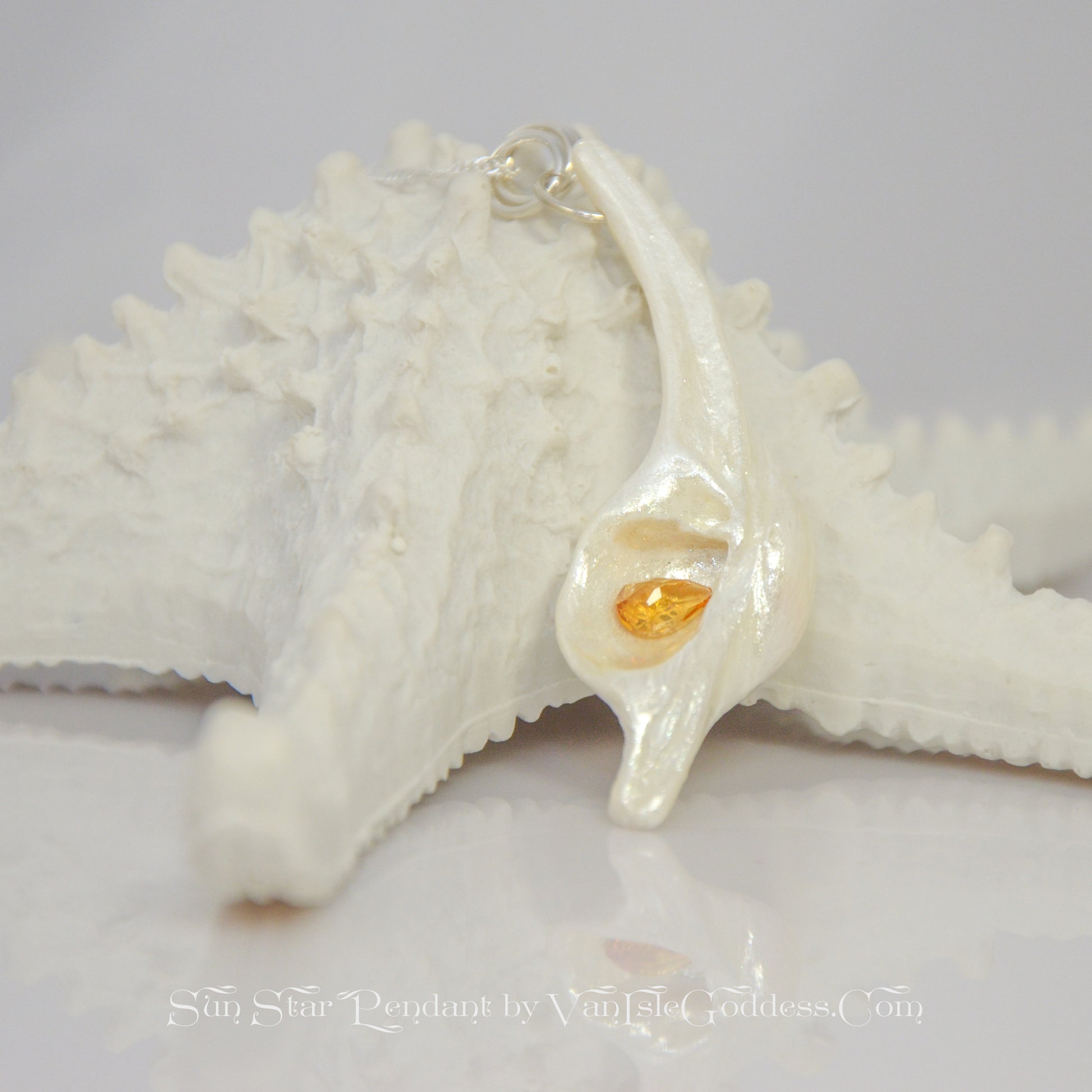 Sun Star natural seashell pendant with a beautiful pear shaped rose cut Citrine. The pendant rests on a starfish. The words on the bottom of the image say: Sun Star pendant by Van Isle Goddess dot com