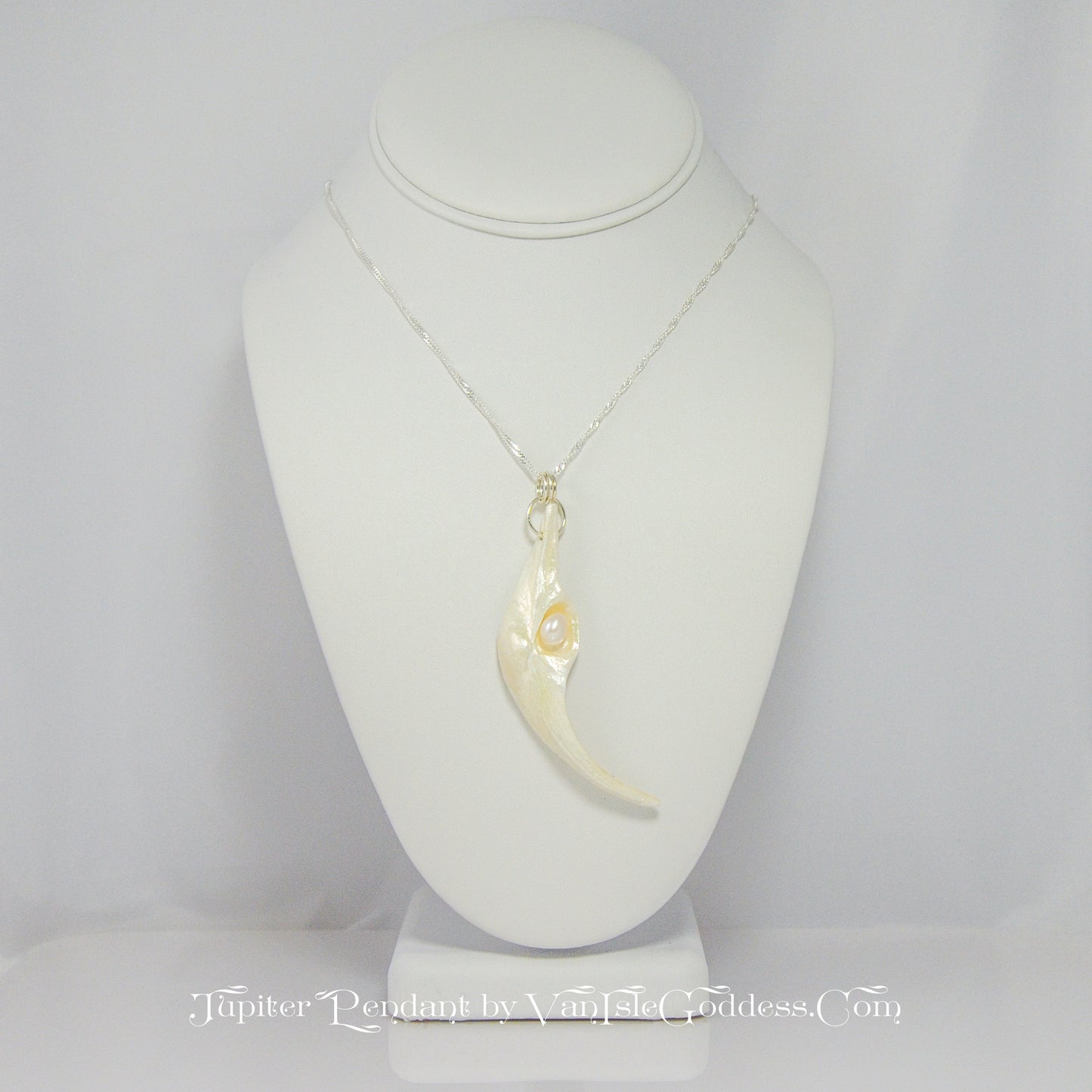 Jupiter is a natural seashell pendant with a real freshwater pearl. The pendant is shown on a white necklace displayer.