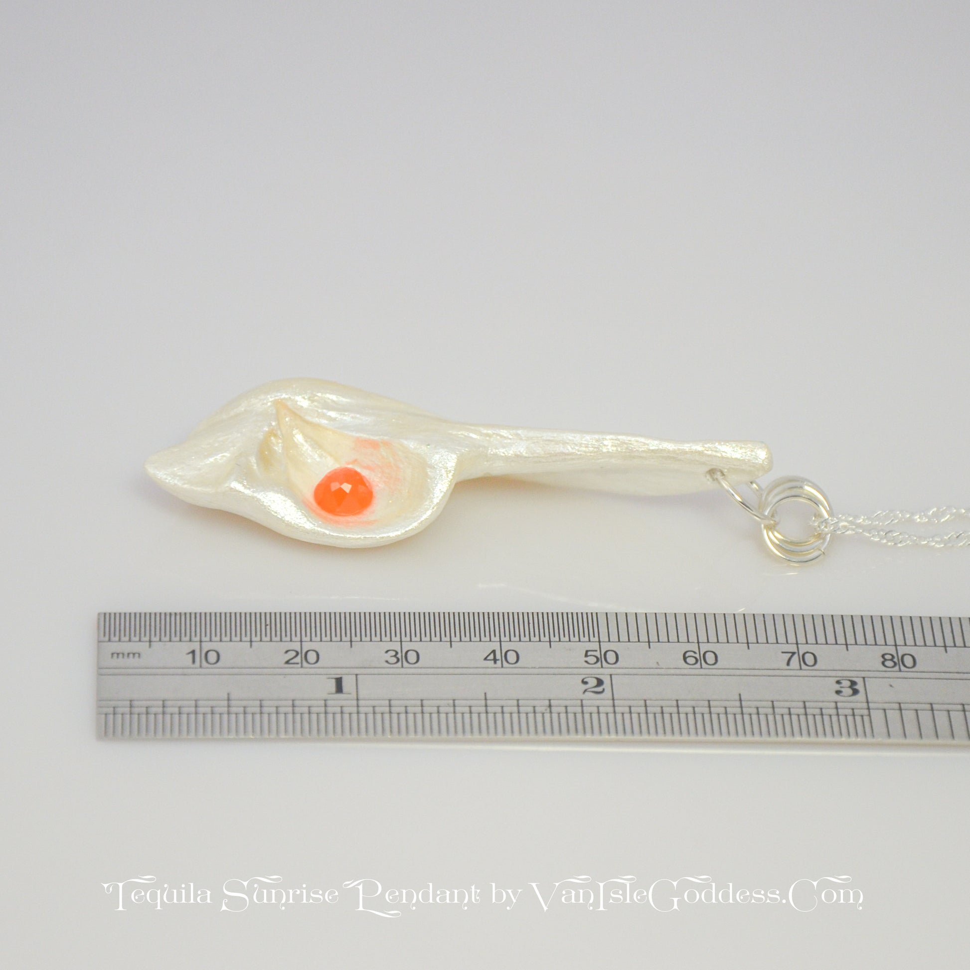 Tequila Sunrise natural seashell pendant a rose cut Carnelian gemstone. The pendant lays next to a ruler to show the viewer the length of the pendant.