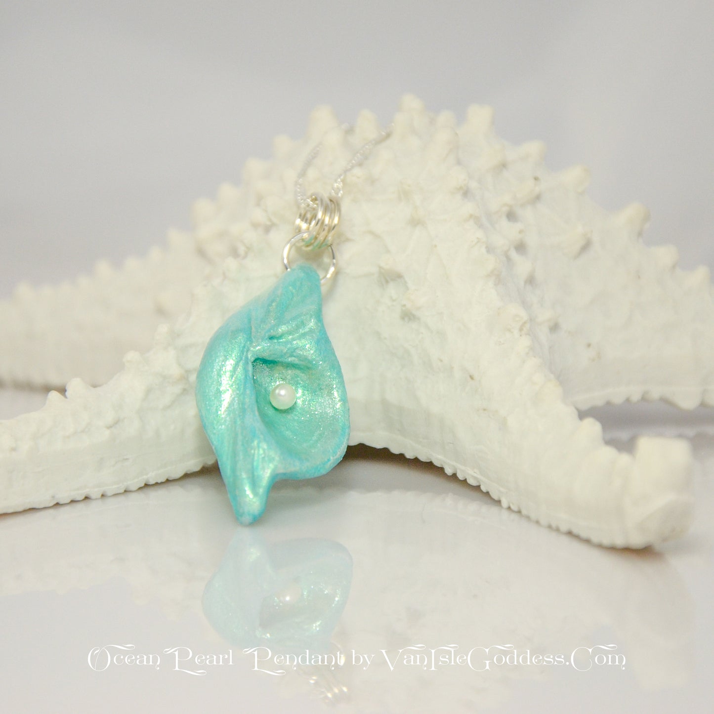 Ocean Pearl natural seashell pendant has a  real freshwater baby pearl. The pendant rests on a starfish. The words on the bottom of the image says:  Ocean Pearl Pendant by Van Isle Goddess dot com