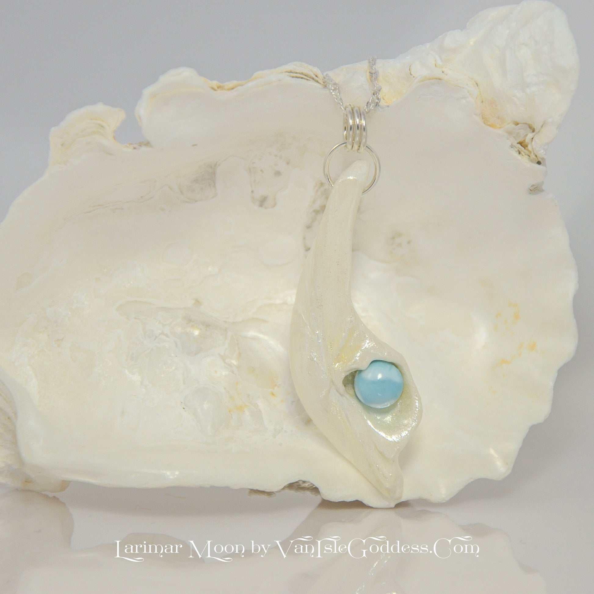 Larimar Moon Natural seashell a beautiful 10 mm Round Larimar Gemstone compliments the pendant. The pendant is shown hanging on a larger seashell.