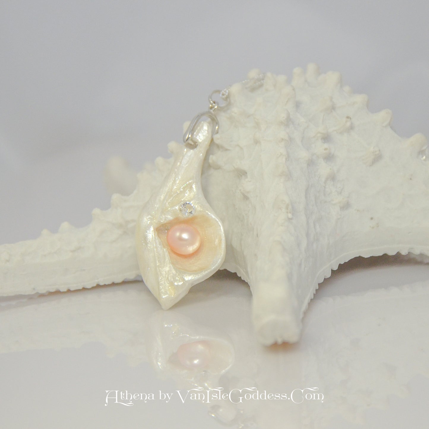 Natural Seashell Pendant with freshwater pearl and faceted herkimer diamond.  The pendant is leaning on a starfish.