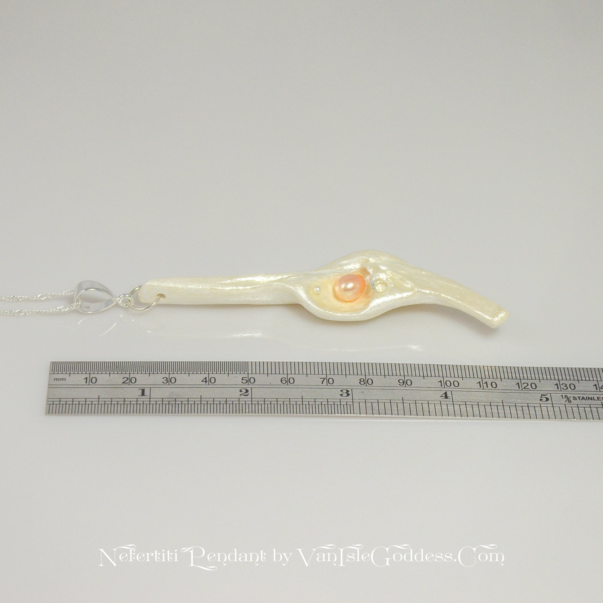 Nefertiti natural seashell and a real 8 mm pink freshwater Pearl, a baby pearl and a 5mm faceted Herkimer diamond compliments the pendant. The pendant is shown along side a ruler so the viewer can see the length of the pendant.