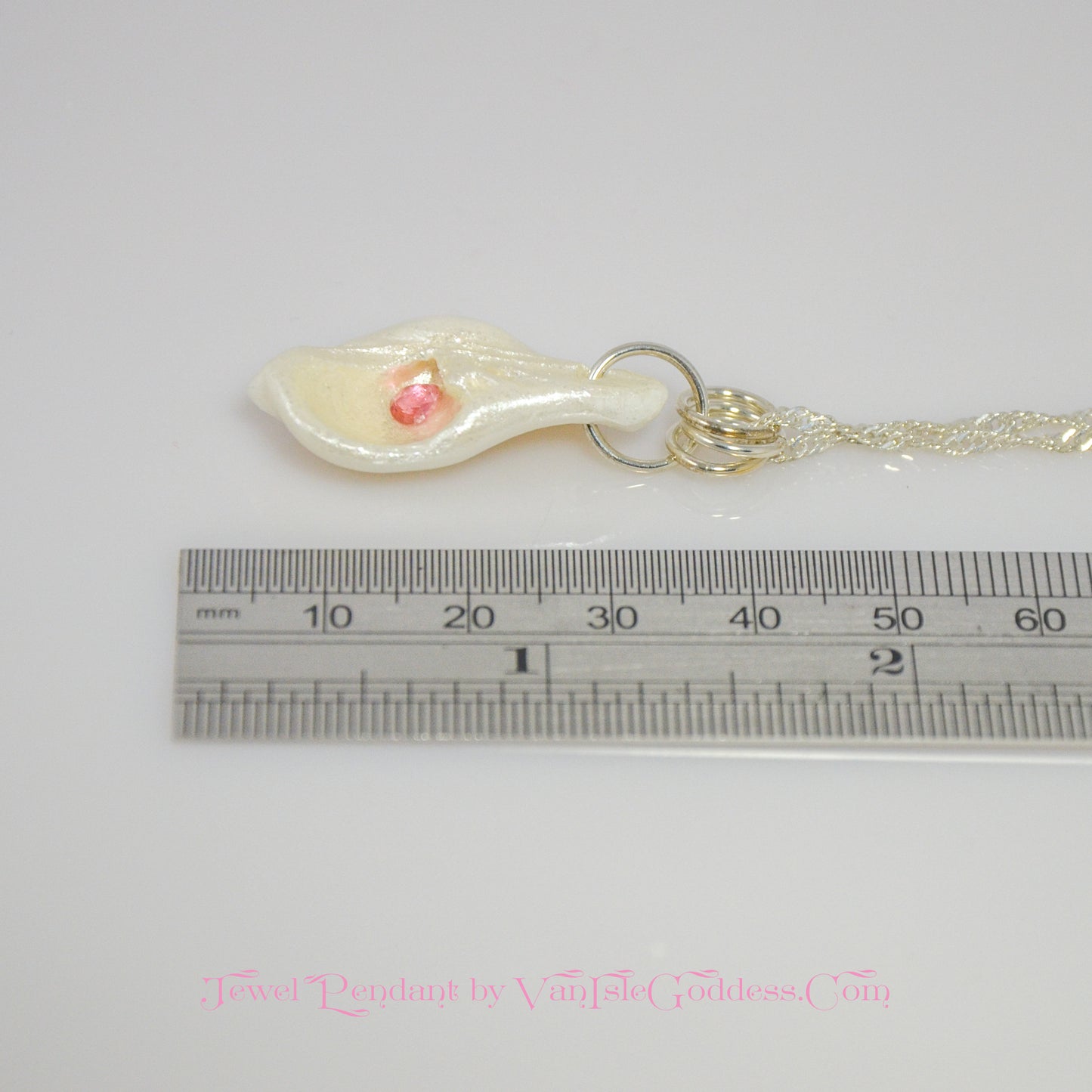Jewel natural seashell with a real teardrop shaped rose cut pink tourmaline gemstone compliments the pendant. The pendant is shown along side a ruler so the viewer can see the length of the pendant.