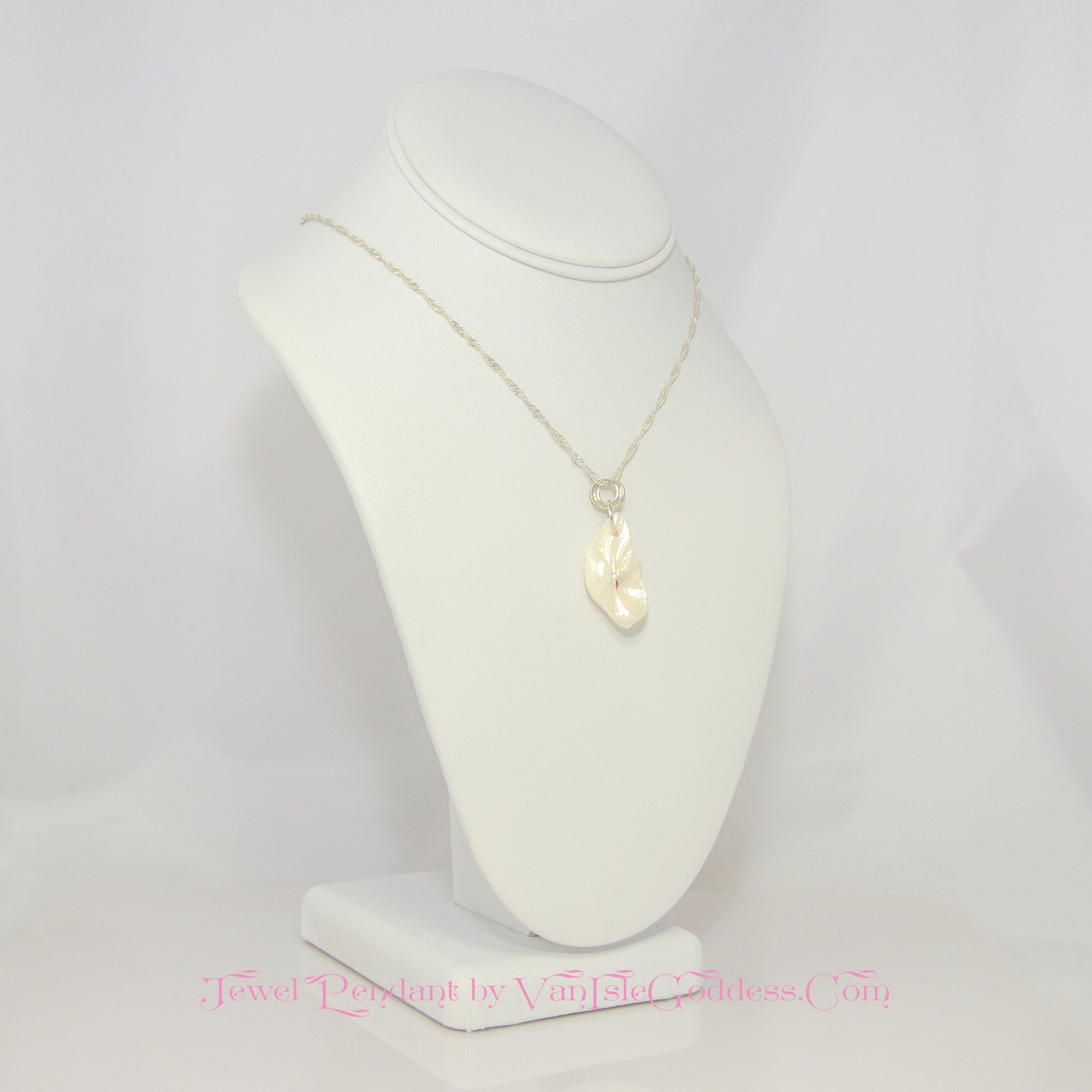 Jewel natural seashell with a real teardrop shaped rose cut pink tourmaline gemstone compliments the pendant. The pendant is turned so the viewer can see the right side of the pendant.