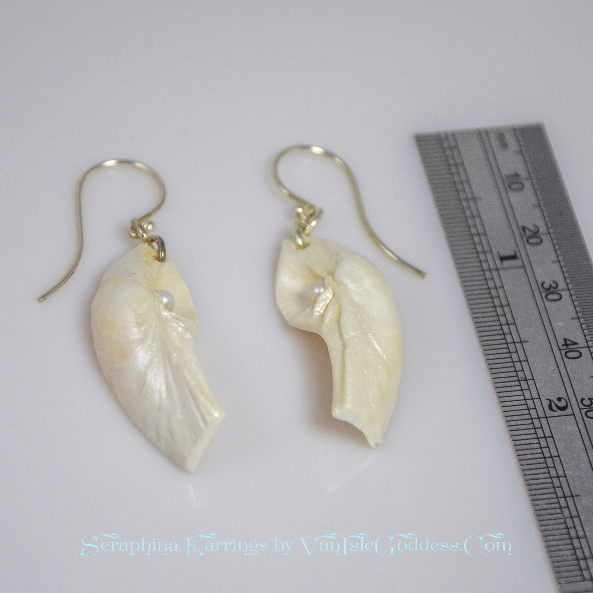 Seraphina natural seashell earrings with real baby freshwater pearls.  The earrings are shown with a ruler so the viewer can see the length of the earrings.