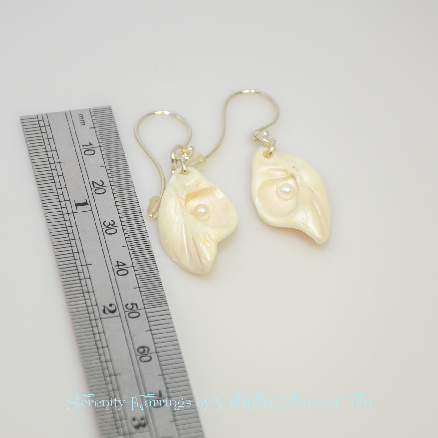 Serenity natural seashell earrings with real baby freshwater pearls. The earrings are next to a ruler so the viewer can see the length of the earrings.