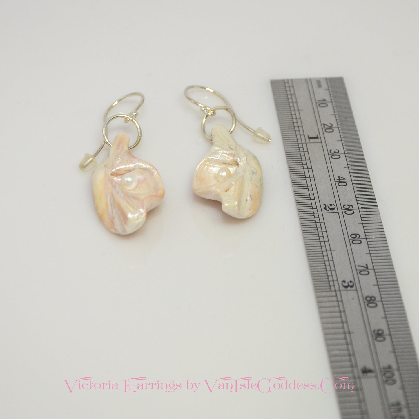 Victoria natural seashell earrings with real baby freshwater pearls.  The earrings are shown with a ruler so the viewer can see the length of the earrings.