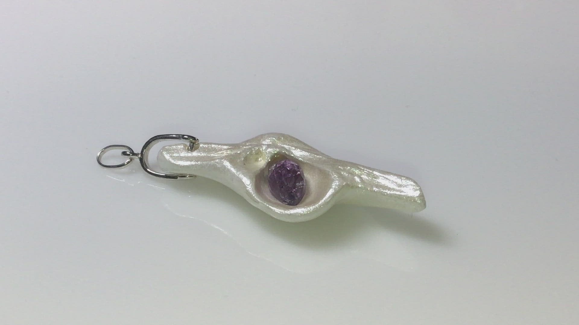A video showing Intuition a natural seashell pendant with a beautiful rose cut marquise Amethyst. 