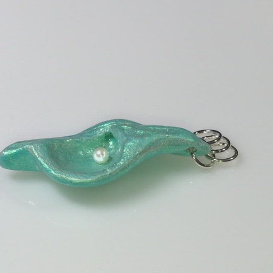 A video showcasing Ocean Pearl natural seashell pendant has a  real freshwater baby pearl. 