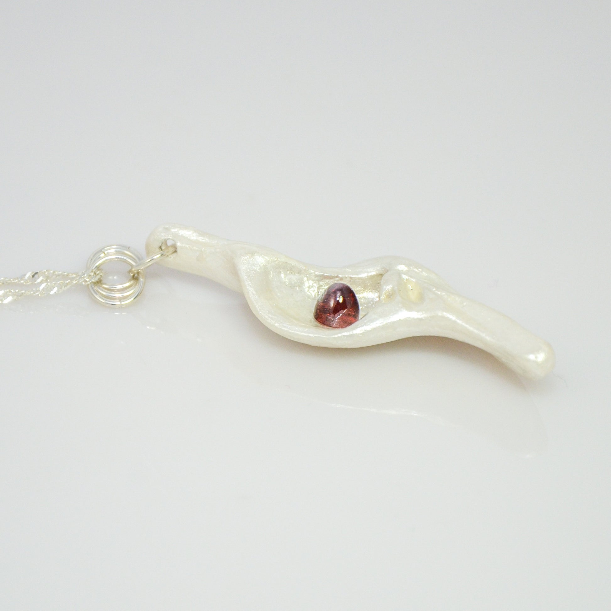 Pomegranate natural seashell pendant is adorned with a stunning Garnet gemstone.